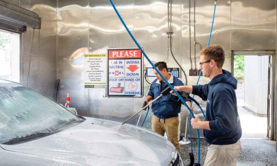 Washing a car in a self-service car wash station with washing foam